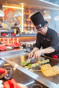 Chef Aris serving food to guest